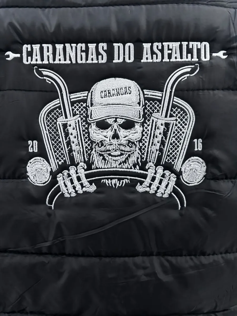 Caveira de motoclube bordada em branco nas costas de uma jaqueta preta