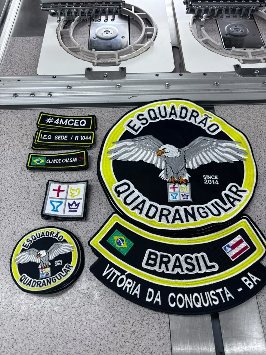 Patches bordados de um grupo, de vários tamanhos, sobre a mesa da máquina